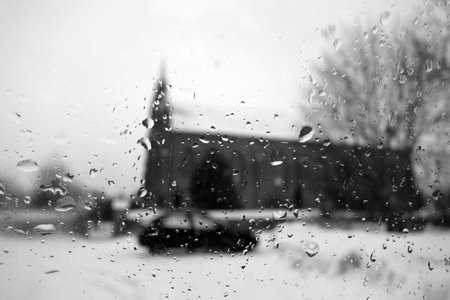 View on winter church and car through wet windshield with rain drops. Background and viewの写真素材