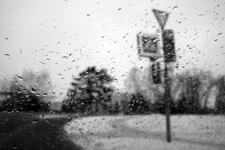 View on winter street and traffic lite through wet windshield with rain drops. Background and viewの写真素材