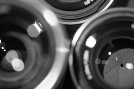 closeup macro of camera lenses with reflections low key black and white image with aperture bladesの写真素材