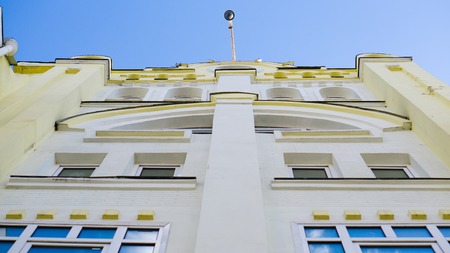 point of view from the ground into the blue sky on office building and security camera on the top roofの写真素材