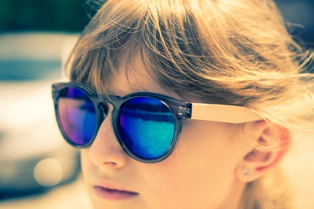 closeup shot of fullface portrait of teenage young girl in mirrored goggles in soft light. vintage look, selective focusの写真素材