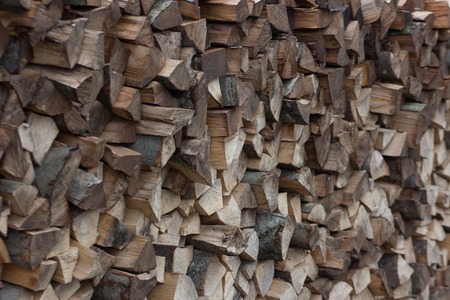 pile of firewood fuel wood woodpile fills the whole frame framed with angleの写真素材