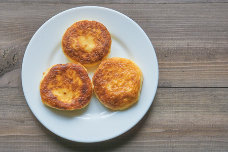 three pancakes on a white plate on a dark table. top view.の写真素材