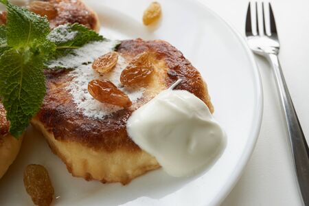 close up view on delicious pancakes with sour cream and sugar powder with fork for those who can't...