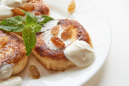 close up shot of pancakes on white plate with raisins and mint. tasty and delicious viewの写真素材