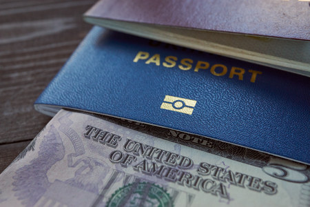 usd currency and ID foreign passport for travel on a wooden table. closeup shotの写真素材