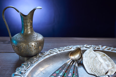 closeup of kitchen silverware cutlery. small decorative jug, vivid teaspoons, cake shovelsの写真素材