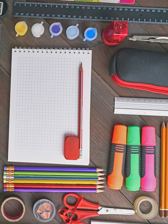 flat lay school tools on a desk. with colorful pencils, markers, paints, ruler, scissors, sharpener,...
