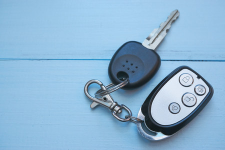 car keys with security alarm on blue desk. top view with lot of copy space