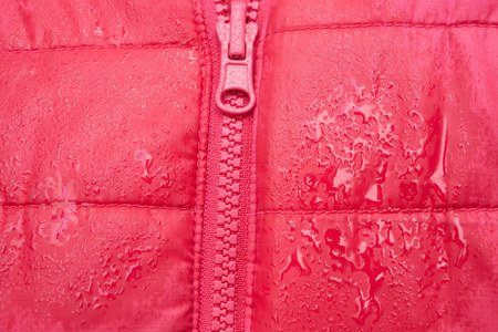 close-up of red jacket with zipper and raindrops after the rain. waterproof clothingの写真素材