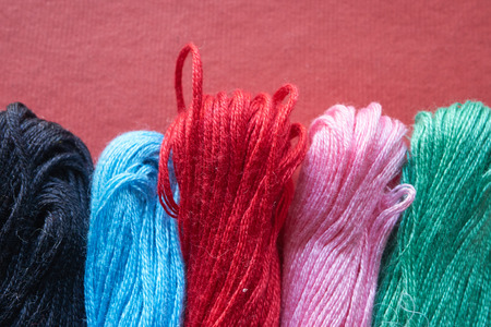 five different vibrant skeins of threads. closeup shot