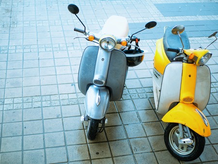 two small vintage retro motorbike scooter for rent for a couple at parking. vintage look with copy spaceの写真素材