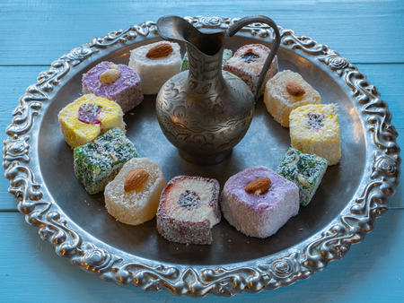 silver silverware tray with lot of vivid colorful turkish delight and small oriental vintage jug jar for tea ceremonyの写真素材