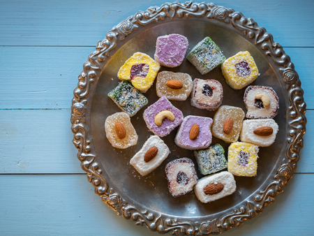 view from top on silver tray full of turkish delight sweets on wooden blue tableの写真素材