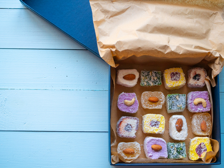 opened box of assorted delicious candys turkish delight on wooden background. top view shot flat lay with copy spaceの写真素材
