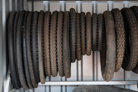 lot of moto, bike, motobike tyres different sizes and types hangs at vehicle part shopの写真素材