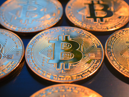 closeup of gold bitcoins on black background. macro low angle shot with selective focus on main coin. virtual gold conceptの写真素材