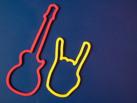 two symbols of red guitar and yellow heavy metal rock devil horns gesture on blue background. rock star concert banner flyerの写真素材