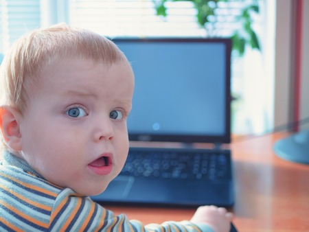 caucasian white astonished little boy child kid with amazed expression on his face. head turned back...