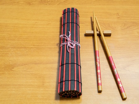 sushi chopsticks and rolled mat on table desk with copy space on left sideの写真素材