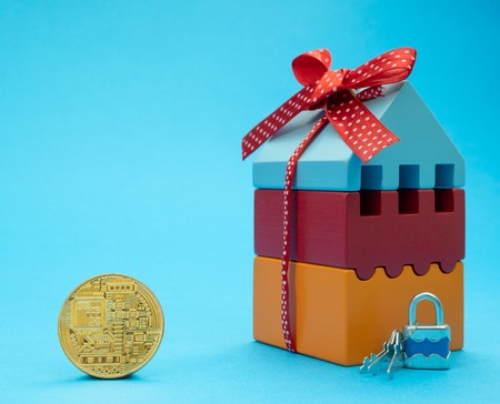 golden coin of cryptocurrency near small house. develop, build, buy, sell, rent property or real estate for crypto currency conceptの写真素材