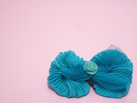 girls blue hair tie bow clip on pink background. closeup shot with color contrast and lot of copy spaceの写真素材