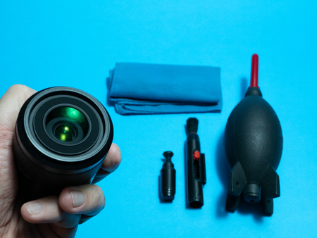 hand with photography lens and cleaning tools on a service deskの写真素材