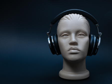 dummy mannequin head with over ear headphones on black background, low key imageの写真素材
