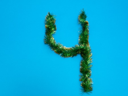number four 4 made of green Christmas tree tinsel on blue backgroundの写真素材