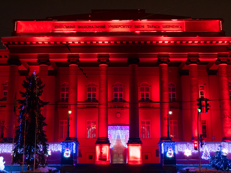 KYIV, UKRAINE - DECEMBER 30, 2018: Facade of Taras Shevchenko National University red building at night with beautiful backlight and winter season Christmas holidays decorationsのeditorial素材