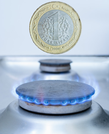 one Turkish coin lira over gas burner. import, transit or utility costs in Turkey conceptの写真素材