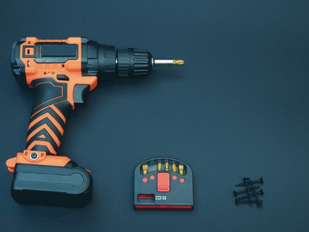 diy hardware store concept. low key toned image of handyman equipment cordless drill, set of bits...