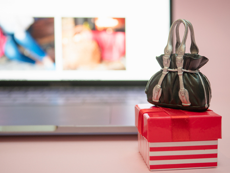 small gift box with black bag near laptop. online retail store concept