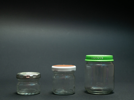 tree glass jars for food on black dark background, ascending sizeの写真素材