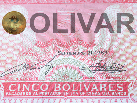 macro extreme close-up image of bolivia currency bolivar with golden bitcoin instead of a letter b at country nameの写真素材