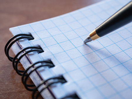 macro extreme closeup image of pen with squared notebook binded with spiralの写真素材