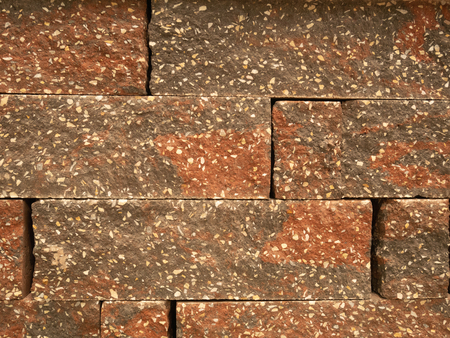 closeup abstract wall pattern red stained bricks with little white blotchesの写真素材