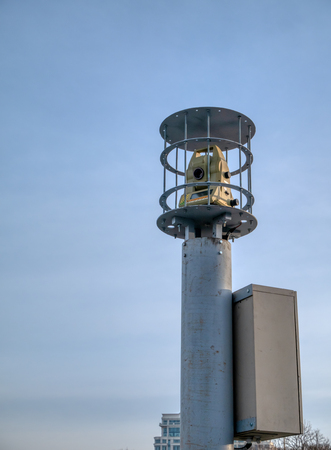 modern theodolite geodesy equipment in security cage on tall columnの写真素材