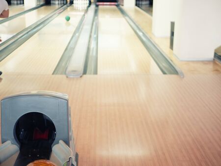 view on empty track at bowling club. blurred background with man throwing ball at pinsの写真素材