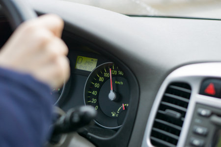 selective focus image of car interior. focus on analog speedometer - overspeeding concept. driver hands on steering wheel. High quality photoの写真素材