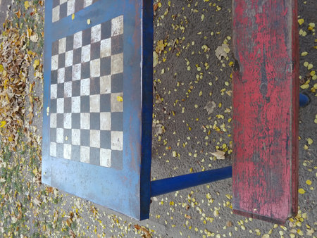 empty chessboard at city public park with wooden benchの写真素材