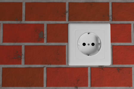 white electric power EU socket in red brick wallの写真素材