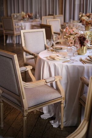 Luxury cozy autumn wedding table decoration in the restaurant. Fresh and dried flowers, roses,...