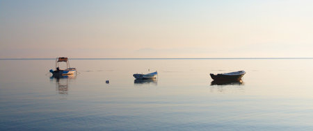 Fishing boats in the setting sun at the resort of Roda on the island of Corfu.のeditorial素材
