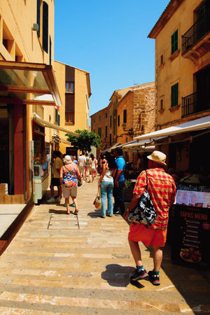 People in the streets of the old town in the city of Alcludia on the island of Mallorca in the Balearic archipelago in the Mediterranean Sea. Spain.の写真素材