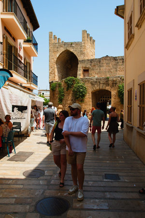 People in the streets of the old town in the city of Alcludia on the island of Mallorca in the Balearic archipelago in the Mediterranean Sea. Spain.の写真素材