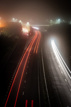 Traffic light trail on foggy night with long exposure, Brighton, East Sussex, UK.