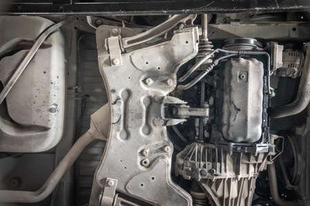 Underneath a motor vehicle onn a ramp in a workshop.の写真素材