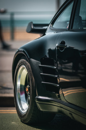Rear quarter of a sports car on a seafront of Brighton beach.の写真素材