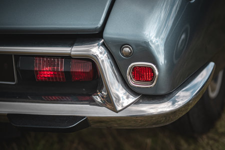 Rear light and a chrome bumper of a old french car on a classic car show.
